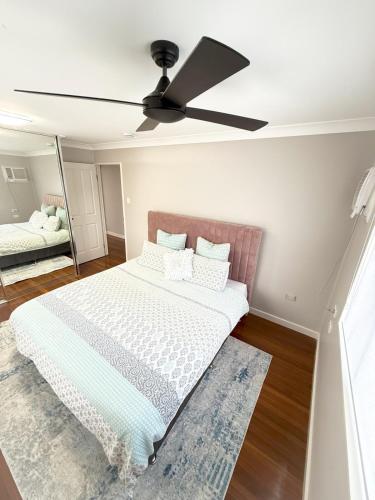a bedroom with a bed with a ceiling fan at Chic Retreat Vintage and Modern in Garbutt Station