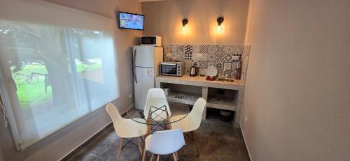 een keuken met witte stoelen en een witte koelkast bij Hotel Maritimo in Villa Gesell