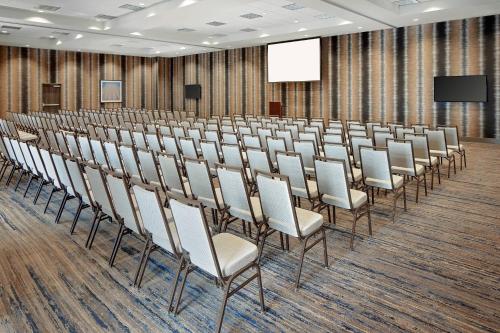 a conference room with a row of chairs and a screen at Courtyard by Marriott Dallas Downtown/Reunion District in Dallas