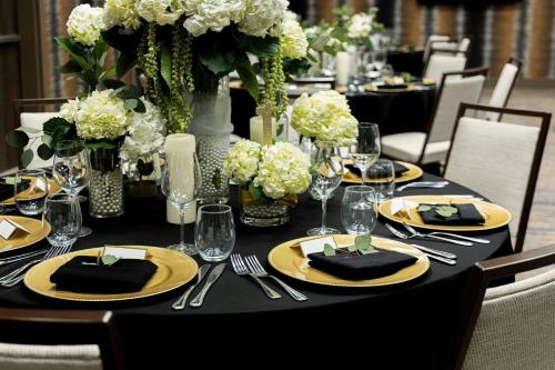 a black table with yellow plates and flowers on it at Courtyard by Marriott Dallas Downtown/Reunion District in Dallas