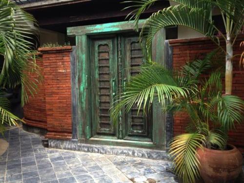 a building with a green door and some plants at Soi One Boutique Bedrooms in Pai