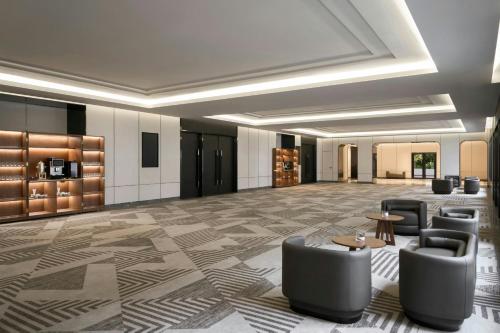 a lobby with chairs and tables in a building at Sheraton Hanoi Hotel in Hanoi