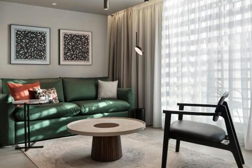a living room with a green couch and a table at MonAsty, Thessaloniki, Autograph Collection in Thessaloniki