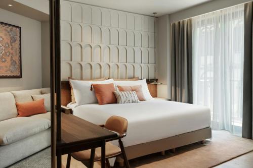 a hotel room with a bed and a couch at MonAsty, Thessaloniki, Autograph Collection in Thessaloniki