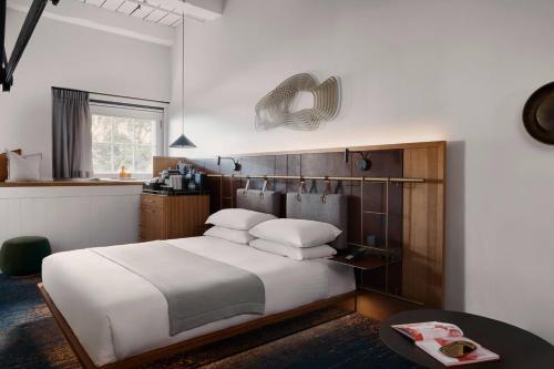 a bedroom with a large white bed and a table at Pier One Sydney Harbour, Autograph Collection in Sydney