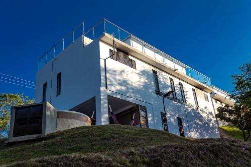 a white building on top of a grassy hill at Casas Campestres Los Miradores de Fruworld in Carmen de Apicalá