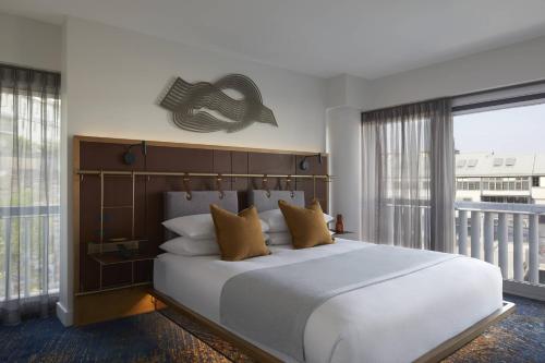 a bedroom with a large white bed and a balcony at Pier One Sydney Harbour, Autograph Collection in Sydney