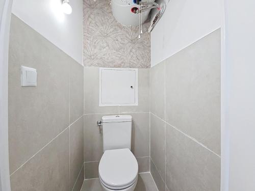 La salle de bains est pourvue de toilettes blanches et d'un mur. dans l'établissement Vacation apartment near sea with private parking, à Antibes