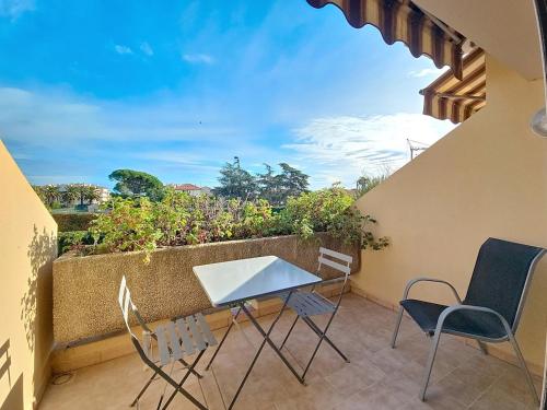 un patio avec une table et des chaises sur un balcon dans l'établissement Vacation apartment near sea with private parking, à Antibes
