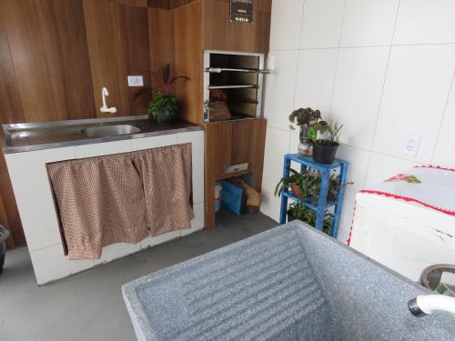 a small kitchen with a sink and a sink at Casa com piscina à 460m do Mar in Matinhos