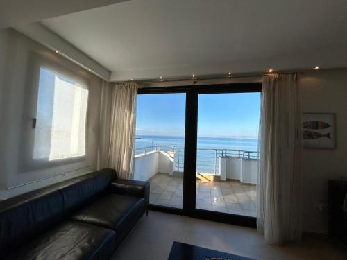 a living room with a couch and a view of the ocean at Sea and Sun Luxury apartment in Neoi Epivates
