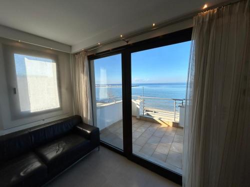 a living room with a couch and a view of the ocean at Sea and Sun Luxury apartment in Neoi Epivates