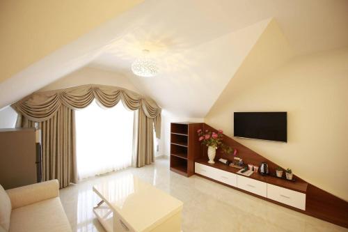 ein Wohnzimmer mit einem TV und einem großen Fenster in der Unterkunft Kim Hoa Hotel in Da Lat