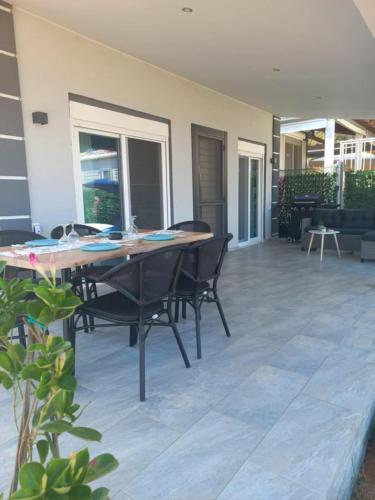 a dining room with a table and chairs on a patio at By the sea in Nea Potidaea
