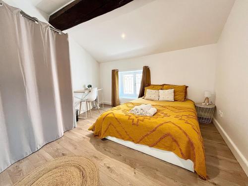 une chambre avec un lit avec une couverture jaune dans l'établissement Luna - Moon 201 - Romans, à Romans-sur-Isère