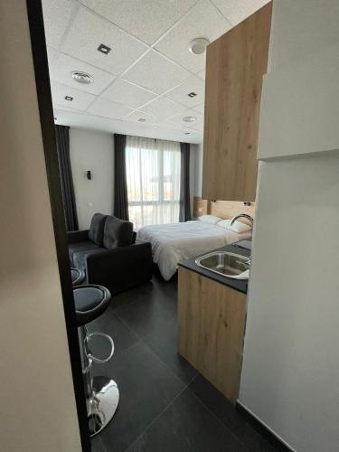 a room with a bed and a sink and a couch at Apartamentos - Mirasur in Parla