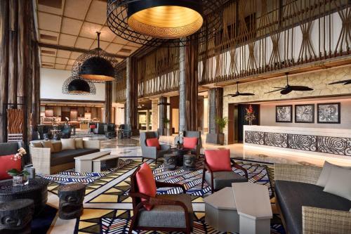 a lobby with couches and chairs in a building at Lapita, Dubai Parks and Resorts, Autograph Collection in Dubai