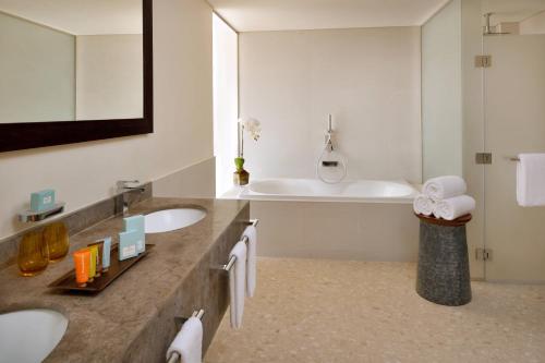 a bathroom with two sinks and a bath tub at Lapita, Dubai Parks and Resorts, Autograph Collection in Dubai
