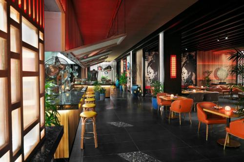 a restaurant with tables and chairs in a room at Lapita, Dubai Parks and Resorts, Autograph Collection in Dubai