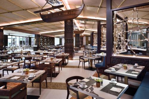 a restaurant with tables and chairs and a hanging basket at Lapita, Dubai Parks and Resorts, Autograph Collection in Dubai