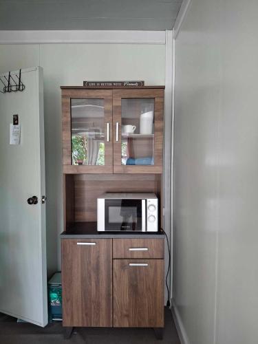 a microwave in a wooden cabinet in a room at AsunEus Farm in Carmen