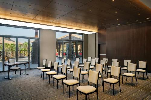 a conference room with chairs and tables and windows at Lapita, Dubai Parks and Resorts, Autograph Collection in Dubai