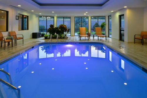 a large swimming pool with blue water in a house at Courtyard by Marriott Harrisburg Hershey in Harrisburg