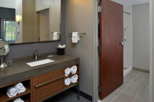 a bathroom with a sink and a mirror at Courtyard by Marriott Harrisburg Hershey in Harrisburg