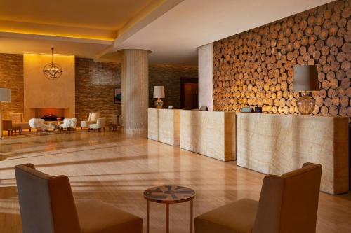 a lobby with a bar with wooden logs on the wall at Park Chalet, Shahdag, Autograph Collection in Shahdag