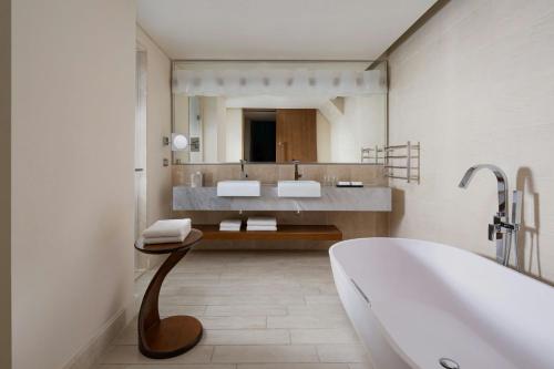 a bathroom with a tub and a large mirror at Park Chalet, Shahdag, Autograph Collection in Shahdag