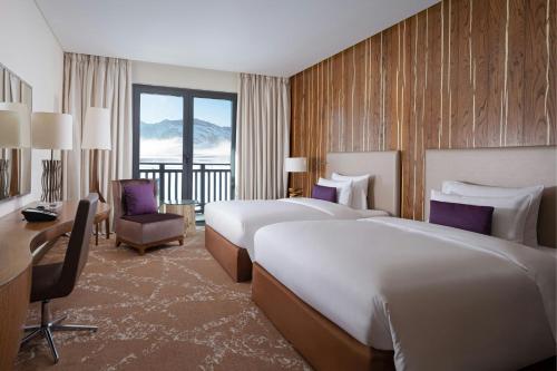 a hotel room with two beds and a desk at Park Chalet, Shahdag, Autograph Collection in Shahdag