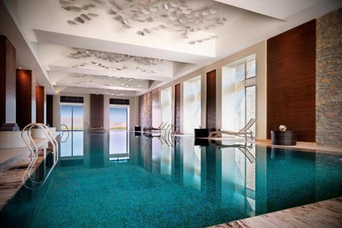 a swimming pool in a hotel with chairs in it at Park Chalet, Shahdag, Autograph Collection in Shahdag