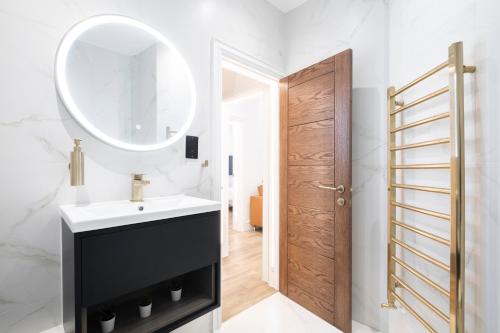 a bathroom with a sink and a mirror at LONDONERS - Harley Street Serviced Apartments in London