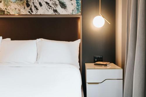 a bedroom with a bed and a table with a lamp at Renaissance Saint Elm Dallas Downtown Hotel in Dallas