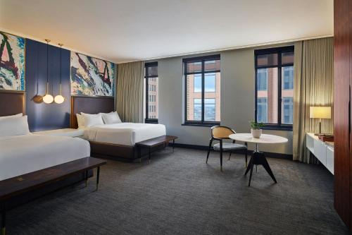 a hotel room with two beds and a table at Renaissance Saint Elm Dallas Downtown Hotel in Dallas
