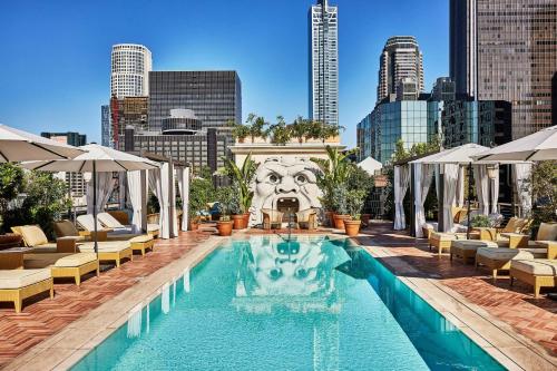 a swimming pool with a city skyline in the background at Hotel Per La, Autograph Collection in Los Angeles