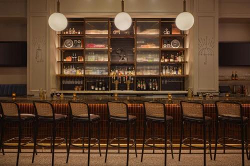 a bar with chairs in front of a counter at Renaissance Saint Elm Dallas Downtown Hotel in Dallas