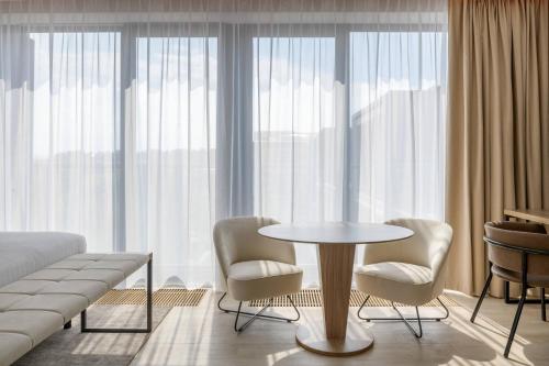 a room with a bed and a table and chairs at AC Hotel by Marriott Krakow in Kraków