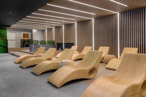 a row of wooden chairs in a room at AC Hotel by Marriott Krakow in Kraków