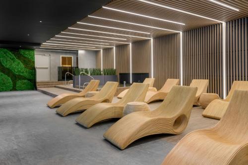 a row of wooden chairs in a room at AC Hotel by Marriott Krakow in Kraków