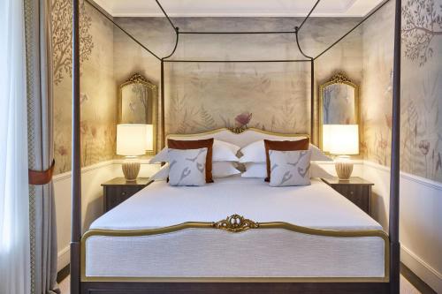 a bedroom with a four poster bed and two lamps at Grotta Giusti Thermal Spa Resort Tuscany, Autograph Collection in Monsummano