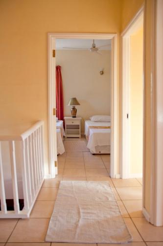 a bedroom with two beds and a hallway at Residence Monte-Cristo in Anse Boileau