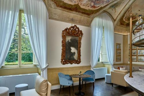 a room with a table and chairs and windows at Grotta Giusti Thermal Spa Resort Tuscany, Autograph Collection in Monsummano