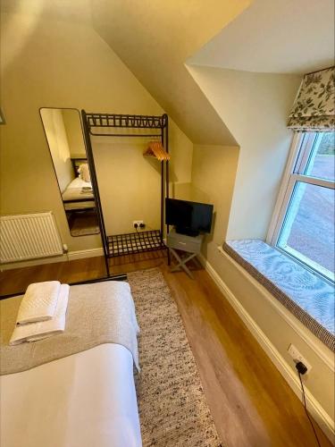 a bedroom with a mirror and a bed and a tv at Stalkers Cottage in Spean Bridge