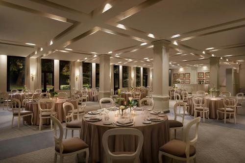 a room with tables and chairs in a room at Grotta Giusti Thermal Spa Resort Tuscany, Autograph Collection in Monsummano