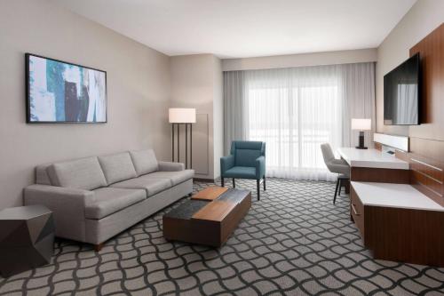 a living room with a couch and a desk at Marriott Dallas Allen Hotel & Convention Center in Allen
