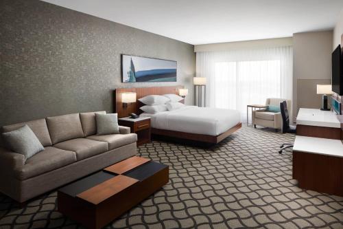 a hotel room with a bed and a couch at Marriott Dallas Allen Hotel & Convention Center in Allen