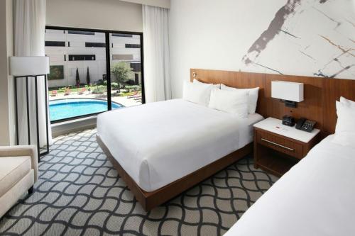 a hotel room with two beds and a pool at Marriott Dallas Allen Hotel & Convention Center in Allen