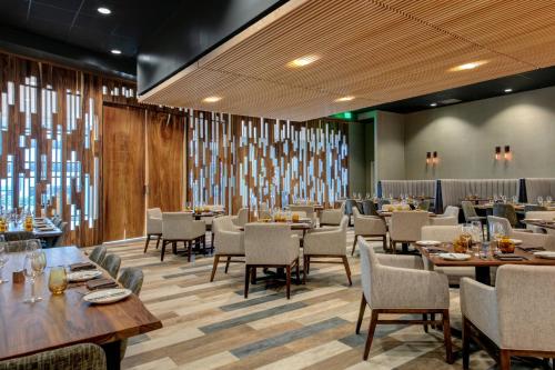 a dining room with wooden tables and chairs at Marriott Dallas Allen Hotel & Convention Center in Allen