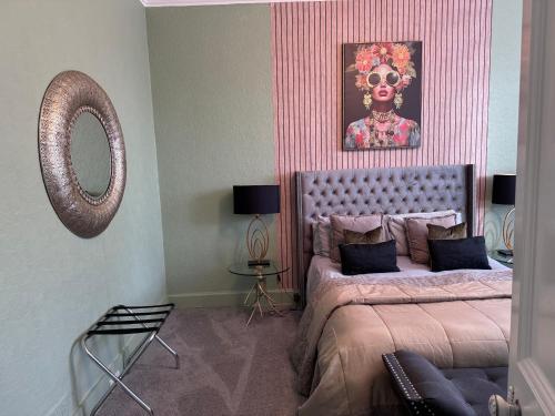 a bedroom with a bed with a skull painting on the wall at No 9 Serviced Apartment in Prestwick